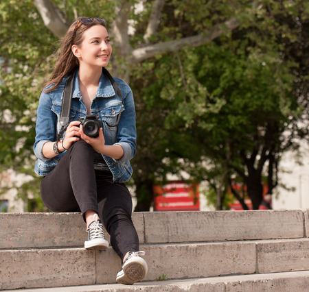 Beautiful happy young brunette taking photographs.の写真素材