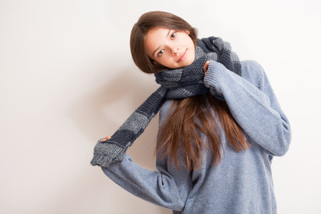 Cold weather coming, cute brunette girl in scarf and sweater.の写真素材