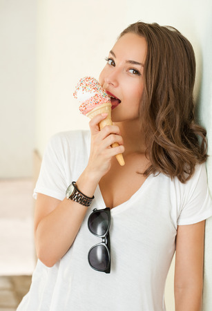 Beautiful young brunette woman having refreshing ice cream.の写真素材