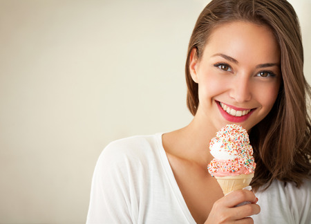 Beautiful young brunette woman having refreshing ice cream.の写真素材