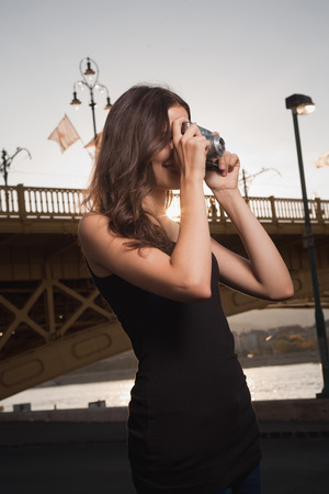 Young brunette woman taking photographs of the city.の写真素材