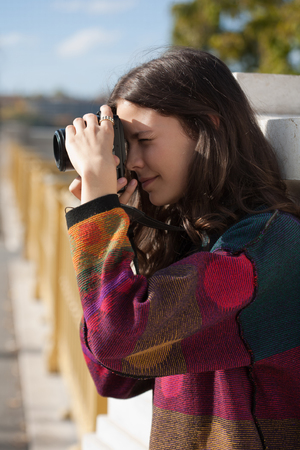 Young brunette woman with ther camera on the streets.の写真素材