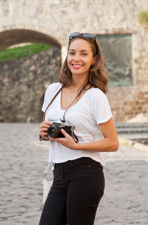 Portrait of a young brunette tourist woman taking photo.の写真素材