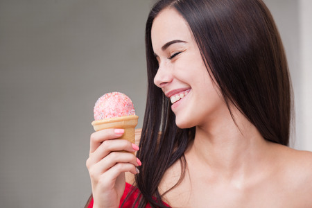 Portrait of a gorgeous young brunette woman having ice cream.の写真素材
