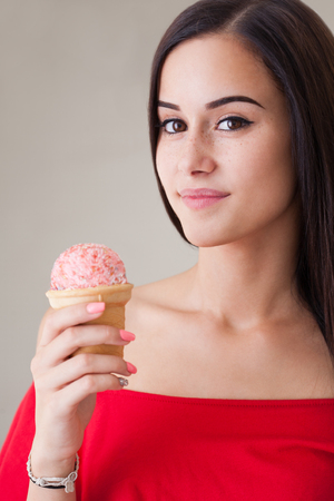 Portrait of a gorgeous young brunette woman having ice cream.の写真素材