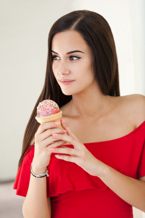 Portrait of a gorgeous young brunette woman having ice cream.の写真素材
