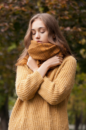Portrait of a young brunette beauty in autumn clothes.の写真素材
