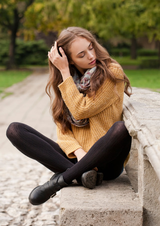 Portrait of a young brunette beauty in autumn clothes.の写真素材