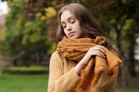 Portrait of a young brunette beauty in autumn clothes.の写真素材