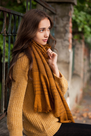 Portrait of a young brunette beauty in autumn clothes.の写真素材
