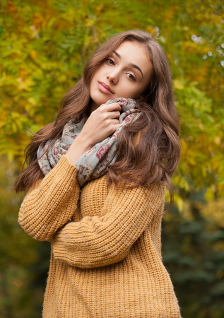 Portrait of a young brunette beauty in autumn clothes.の写真素材
