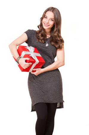 Portrait of a gorgeous young brunette woman with shiny red gift box.の写真素材