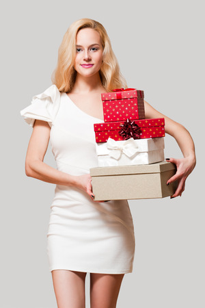 Portrait of a blond Christmas beauty holding gift boxes.の写真素材