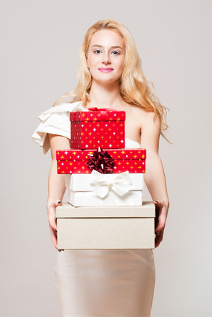 Portrait of a blond Christmas beauty holding gift boxes.の写真素材