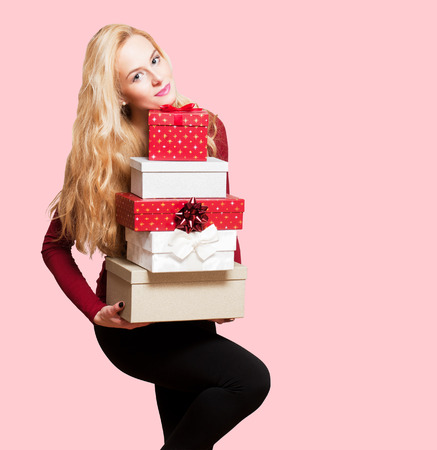 Portrait of a blond Christmas beauty holding gift boxes.の写真素材