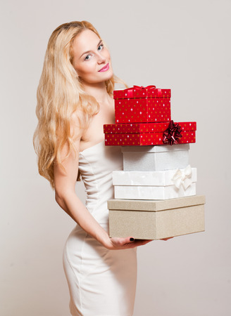 Portrait of a blond Christmas beauty holding gift boxes.の写真素材
