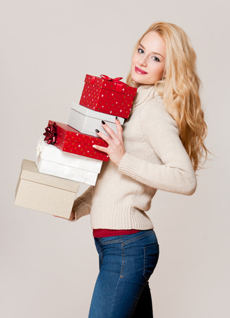 Portrait of a blond Christmas beauty holding gift boxes.の写真素材