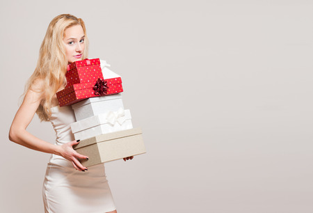 Portrait of a gorgeous young blond woman with Christmas gift boxes.の写真素材