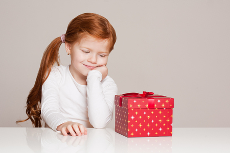 Portrait of a festive little girl with gift box.の写真素材