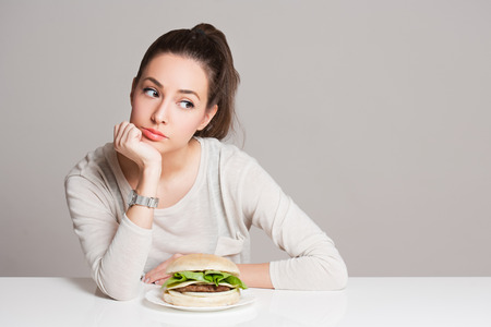 Portrait of a young brunette beauty offering nutrition choices.の写真素材