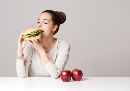 Portrait of a young brunette beauty offering nutrition choices.の写真素材