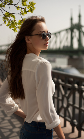 Portrait of a young fashionable brunette woman having fun outdoors in the city.の写真素材