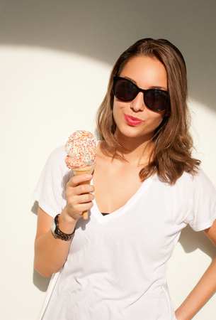 Beautiful young brunette woman having refreshing ice cream.の写真素材