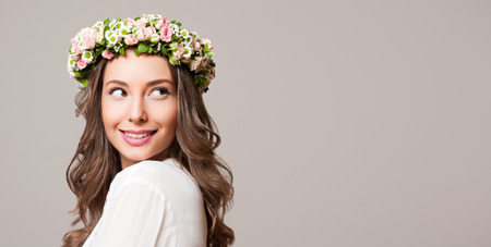Portrait of a gorgeous brunette woman wearing spring flower wreath.の写真素材