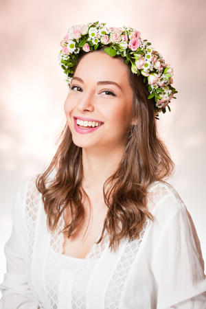 Portrait of a gorgeous brunette woman wearing spring flower wreath.の写真素材