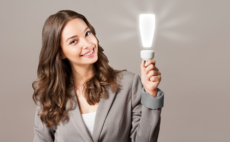 Creative ideas concept, beautiful businesswoman holding glowing symbol.の写真素材
