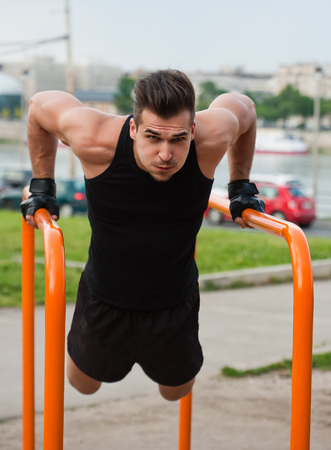 Handsome young athlete man doing urban street workout.