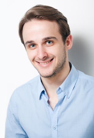 Portrait of a friendly smiling handsome young brunette man.の写真素材