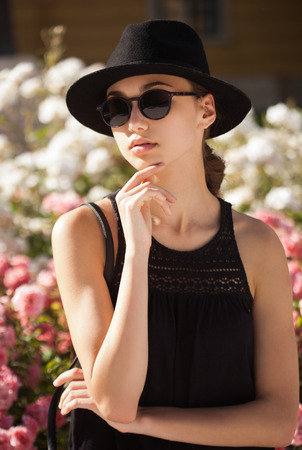 Portrait of a stylish fashionable young brunette beauty outdoors in summer.の写真素材