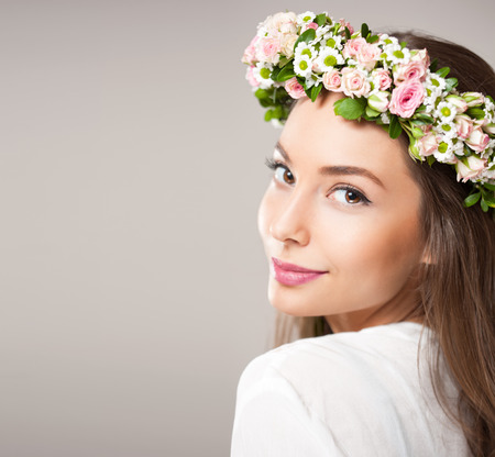 Portrait of a gorgeous brunette woman wearing spring flower wreath.の写真素材