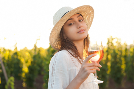 Portrait of a gorgeous brunette woman having wine fun in the vineyards.の写真素材