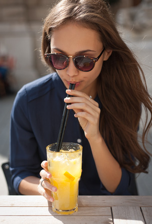 Portrait of a fashionable stylish young woman at outdoors food place.の写真素材