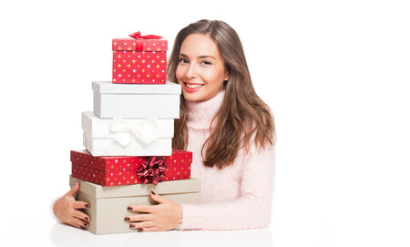 Portrait of a gorgeous young brunette woman holding decorative Christmas gift boxes.の写真素材