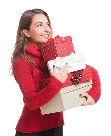 Portrait of a gorgeous young brunette woman holding decorative Christmas gift boxes.の写真素材