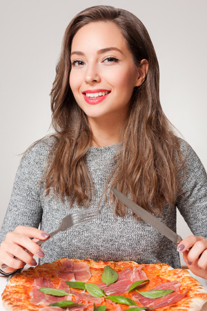 Beautiful young brunette woman eating Italian meal.の写真素材