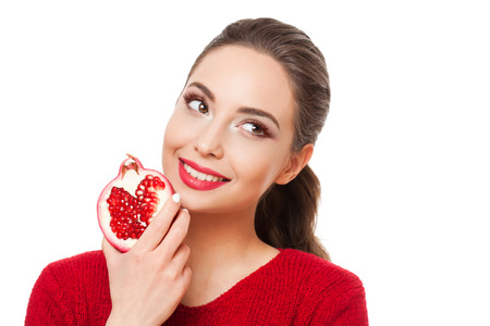 Young brunette beauty on colorful makeup holding fresh fruits full of vitamins.の写真素材