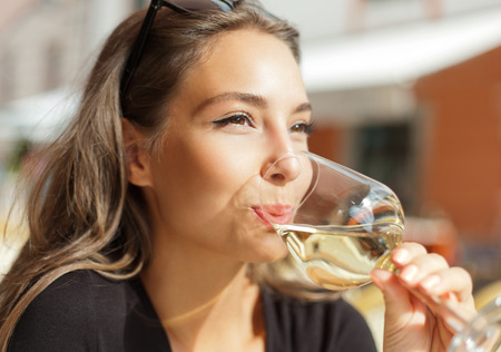 Portrait of a gorgeous young brunette woman having wine fun.の写真素材