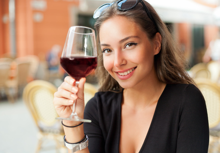 Portrait of a gorgeous young brunette woman having wine fun.の写真素材