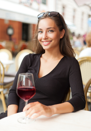 Portrait of a gorgeous young brunette woman having wine fun.の写真素材