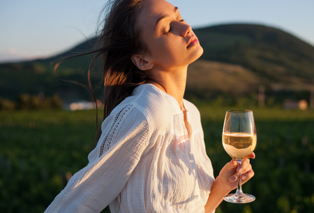 Portrait of a gorgeous brunette woman having wine fun in the vineyards.の写真素材