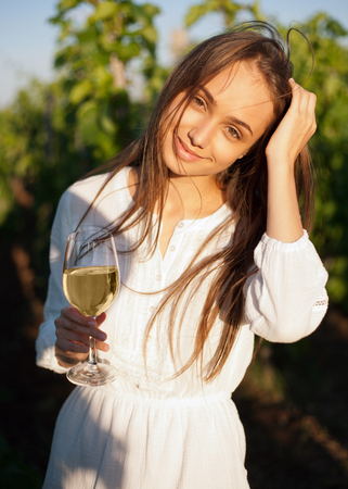 Portrait of a gorgeous brunette woman having wine fun in the vineyards.の写真素材