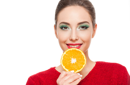 Young brunette beauty on colorful makeup holding fresh fruits full of vitamins.の写真素材