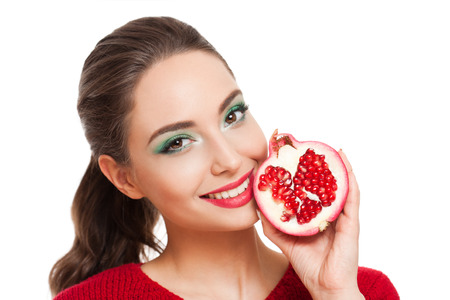 Young brunette beauty on colorful makeup holding fresh fruits full of vitamins.の写真素材