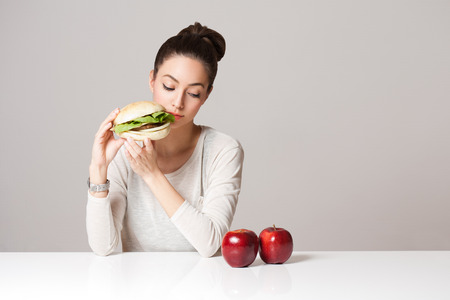 Portrait of a gorgeous young brunette woman showing diet food choices.の写真素材