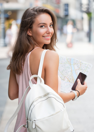 Beautiful young tourist woman using smart phone for navigation.の写真素材