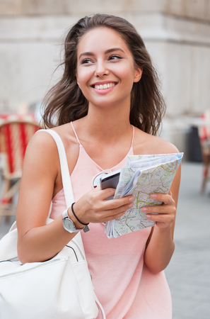 Beautiful young tourist woman using smart phone for navigation.の写真素材